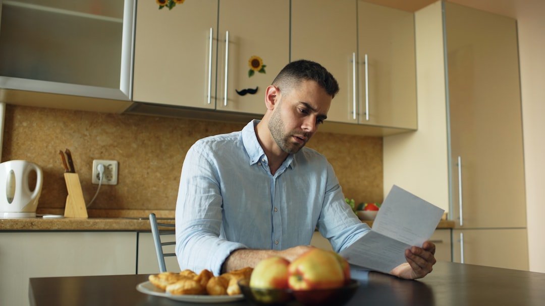 Person reading a notice about an unpaid bill, feeling concerned